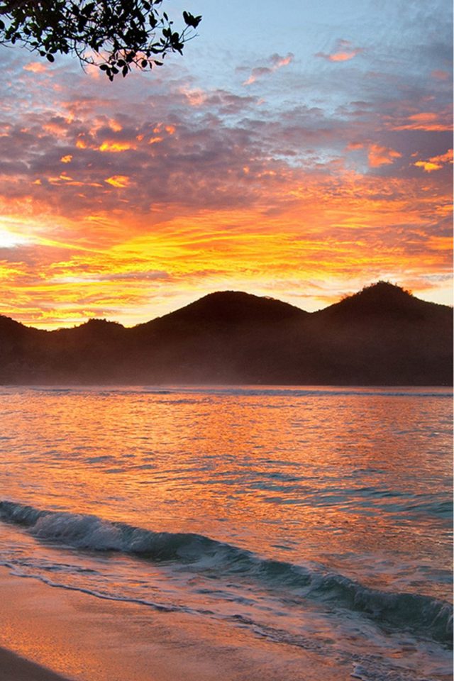 Sunset with mountains on beach Android wallpaper
